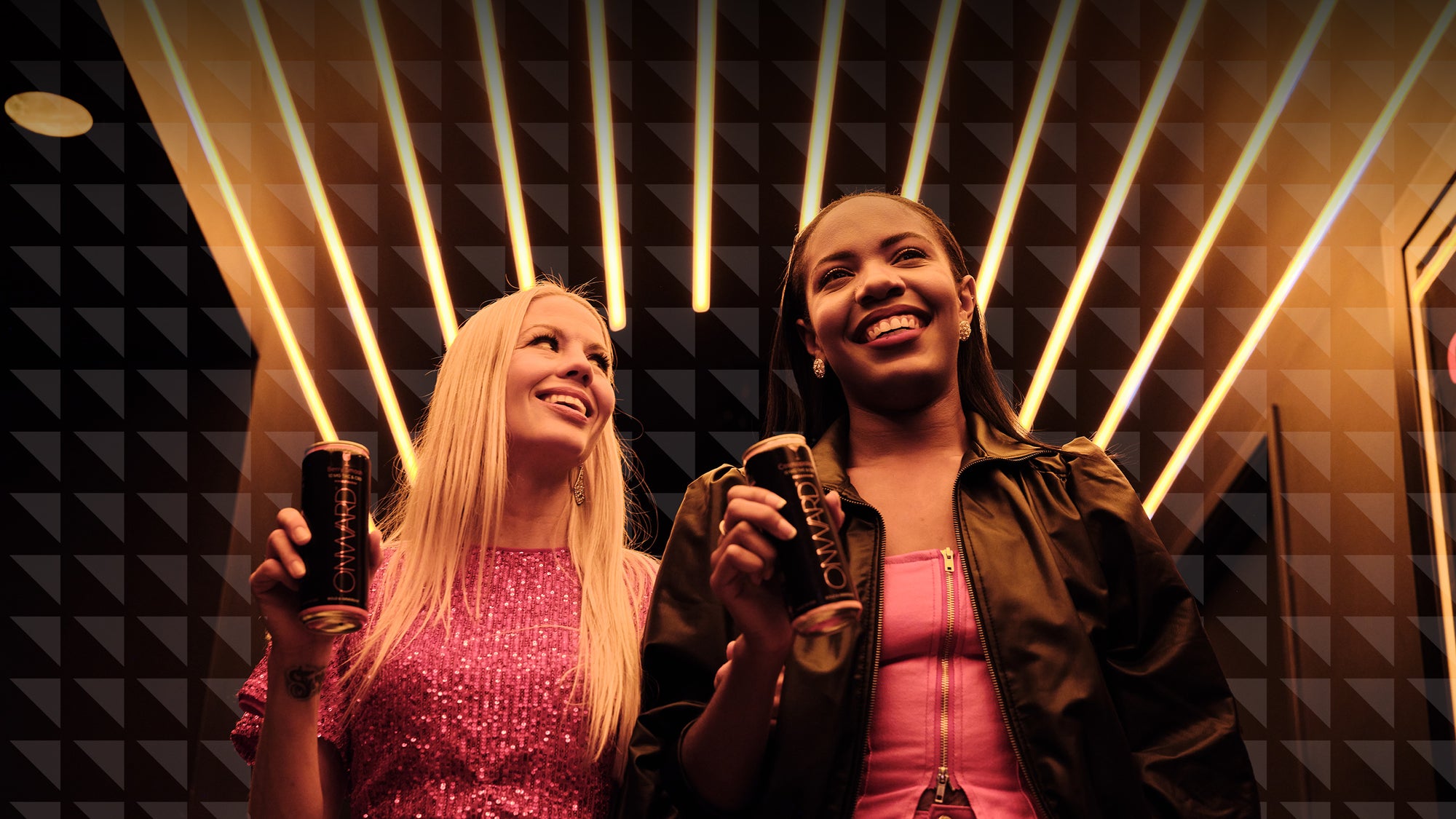 Two women holding Onwards in a bar with neon lights
